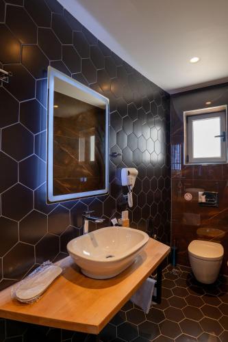 a bathroom with a large sink and a toilet at Hotel Teuta in Sarandë