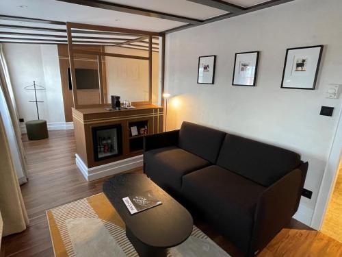 a living room with a couch and a fireplace at Hotel Le Colombier in Obernai