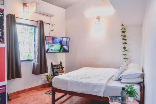 een slaapkamer met een bed en een raam bij U.R.D.Ki Hostel in Anjuna