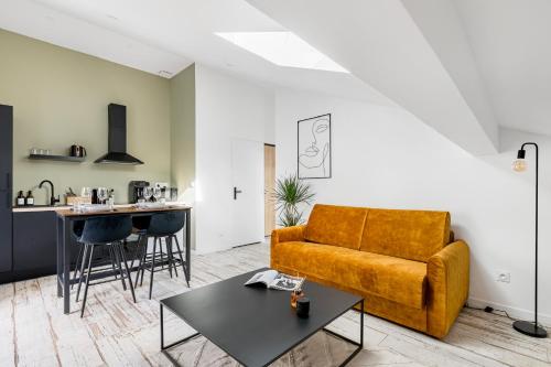 un salon avec un canapé et une table dans l'établissement COCON - Appartement neuf et confort, à Saint-Étienne