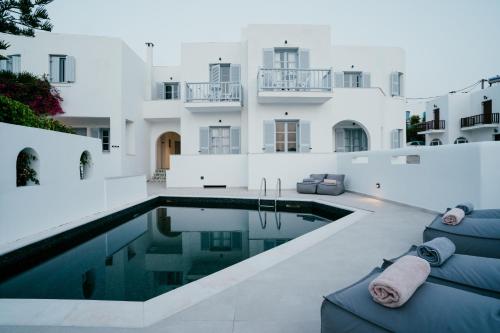 a house with a swimming pool in front of a building at Sunrise Paros in Naousa