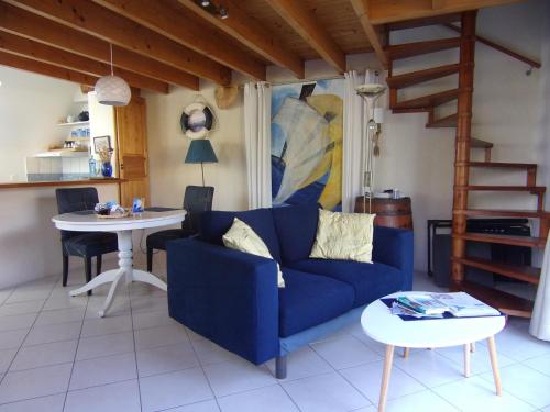 un salon avec un canapé bleu et une table dans l'établissement Roscoff Santec Maison Mer Bretagne, à Santec