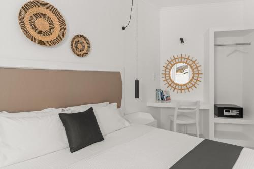 una camera con letto bianco e specchio di Sunrise Paros a Naoussa