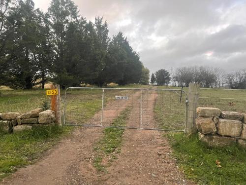 a gate on a dirt road in a field at Clover at Lexington Park by Tiny Away in Tarlo