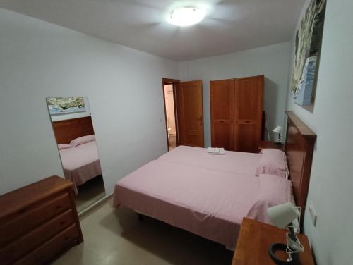 1 dormitorio con cama, tocador y mesa en Apartamentos Proamar, en Torre del Mar