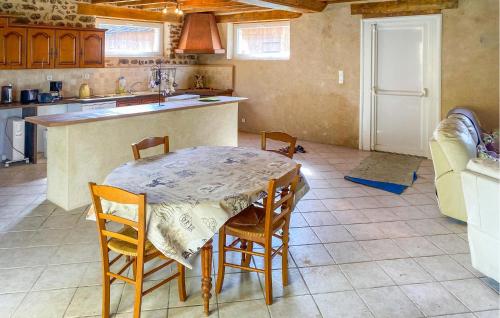 une cuisine avec une table et des chaises dans une pièce dans l'établissement Lake Front Home In Moitron-Sur-Sarthe, à Moitron-sur-Sarthe