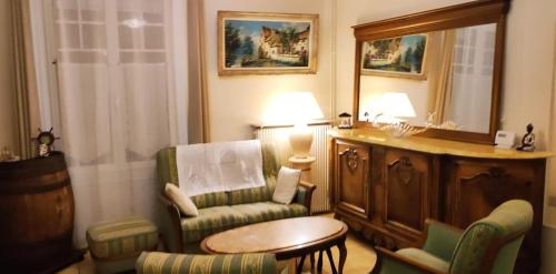 un salon avec une chaise et une table dans l'établissement Maison de vacances avec jardin et parking privés, à Ouistreham