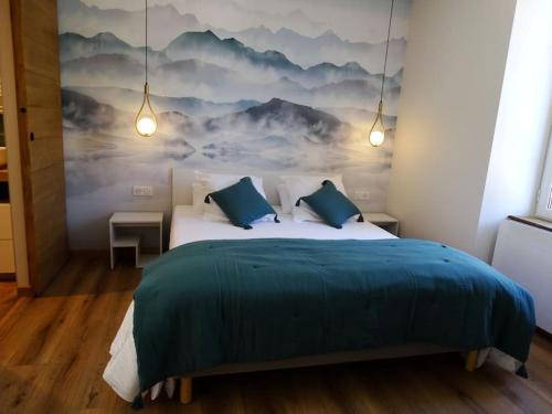 a bedroom with a bed with a painting on the wall at Gîte Chez Arnaoutou in Beaudéan