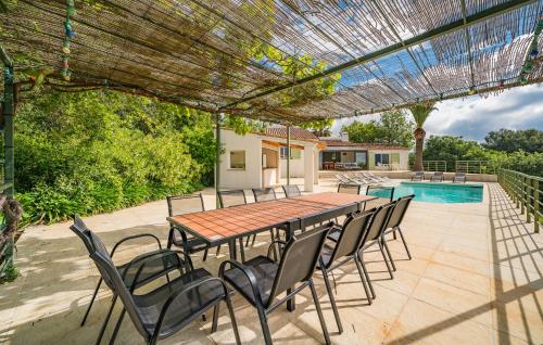 un patio avec une table et des chaises et une piscine dans l'établissement House With Pool Panoramic View, à Saint-Cézaire-sur-Siagne