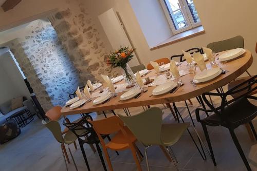 a long table in a room with chairs at Gîte Chez Arnaoutou in Beaudéan