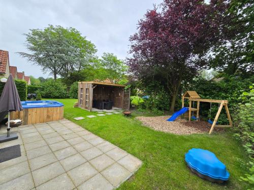 a backyard with a playground and a wooden house at New 3 bedroom house 7 people in Ewijk