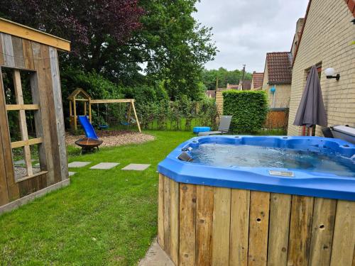 a hot tub in a yard with a swing at New 3 bedroom house 7 people in Ewijk