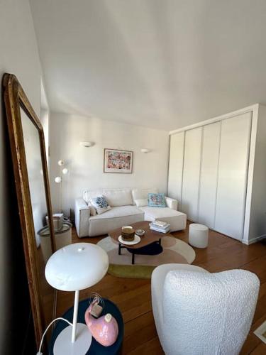 un salon avec un canapé blanc et une table dans l'établissement Maison Moufetard, à Paris