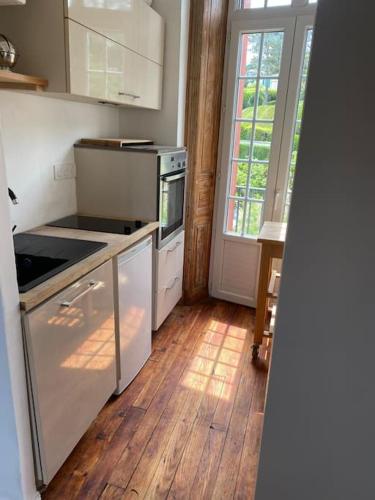 une cuisine avec des appareils blancs et un parquet dans l'établissement Studio à deux pas de la grande plage, à Biarritz