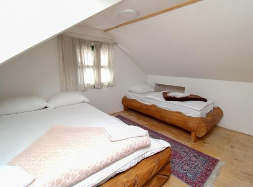 a bedroom with two beds and a window at Ethno Village Dolina Mira in Pale