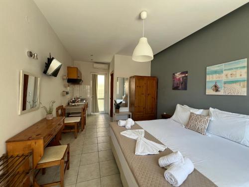 a bedroom with a large bed and a dining room at Artemis Rooms - Beach at Your Doorstep in Platanias