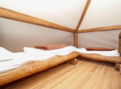 two beds in a room with wooden floors at Ethno Village Dolina Mira in Pale