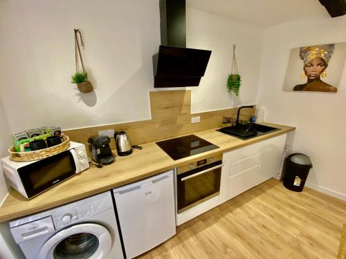 Il comprend une cuisine équipée d'un lave-linge, d'un évier et d'un four micro-ondes. dans l'établissement La Grange Du Bien-être, à Liausson