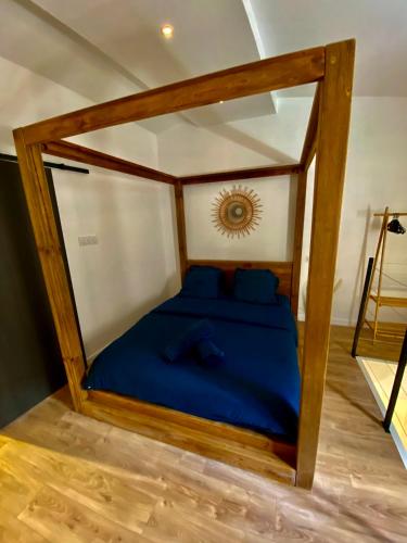 - un lit avec des draps bleus dans une chambre dans l'établissement La Grange Du Bien-être, à Liausson