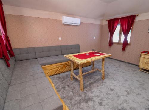 a living room with a table and a couch at Ethno Village Dolina Mira in Pale