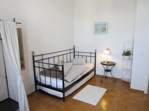 a small bedroom with a bed and a table at Guest house - Maison d'hôtes "Relais des Saars" in Neuchâtel