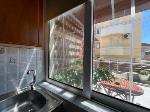 a kitchen window with a sink and a table on a balcony at Artemis Rooms - Beach at Your Doorstep in Platanias