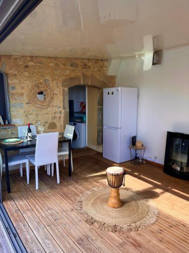 - un salon avec une table et un réfrigérateur blanc dans l'établissement Appartement Alès, à Alès