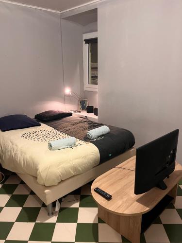 - une chambre avec 2 lits et un bureau avec un ordinateur dans l'établissement Appartement Alès, à Alès
