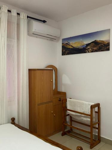 Himo Guest Inn في دهيفالا: غرفة نوم بسرير وخزانة خشبية