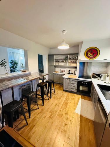 une cuisine avec une table et des chaises dans une cuisine dans l'établissement Belle maison avec jardin expose plein sud proche centre ville, à Caen