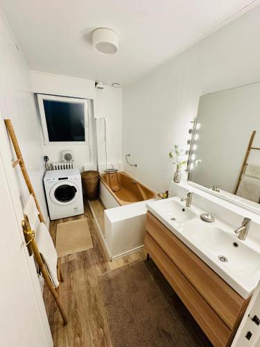 une salle de bain avec un lavabo, une baignoire et un miroir dans l'établissement Belle maison avec jardin expose plein sud proche centre ville, à Caen