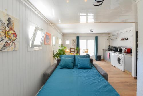 - un grand lit bleu dans une petite pièce dans l'établissement L'Escapade de Creully - Appt 2p avec grande terrasse, à Creully