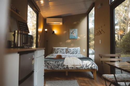 1 dormitorio con 1 cama en una casa pequeña en Pekapeka Tiny House, en Owaka