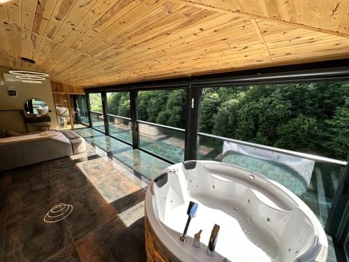 eine Badewanne im Bad mit einem großen Fenster in der Unterkunft TUVA VİLLA Bungalov in Çamlıhemşin