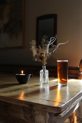 a wooden table with a candle and a vase of flowers at The Fleur de Lys in Dorchester on thames