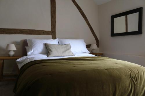 a bedroom with a large bed with white sheets and pillows at The Fleur de Lys in Dorchester on thames