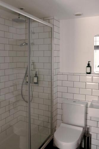 a bathroom with a toilet and a glass shower at The Fleur de Lys in Dorchester on thames