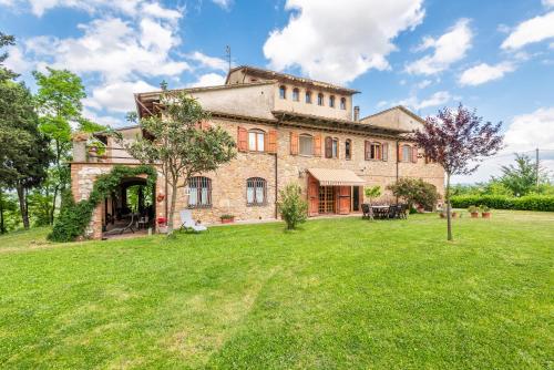 a large brick building with a yard in front of it at Appartamento San Benedetto in San Gimignano