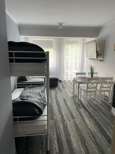 una stanza con un letto a castello e un tavolo e un tavoloasteryasteryasteryastery di Apartament Planeta 209 a Mielno