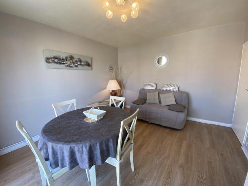un salon avec une table et un canapé dans l'établissement Appartement Quartier Arago - Clocher St Pierre - 500m de la plage, à Les Sables-dʼOlonne