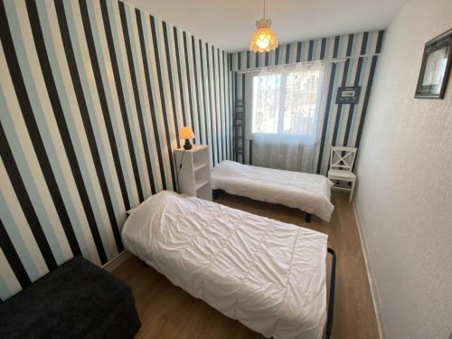 - une chambre avec 2 lits et un mur rayé dans l'établissement Appartement Quartier Arago - Clocher St Pierre - 500m de la plage, à Les Sables-dʼOlonne