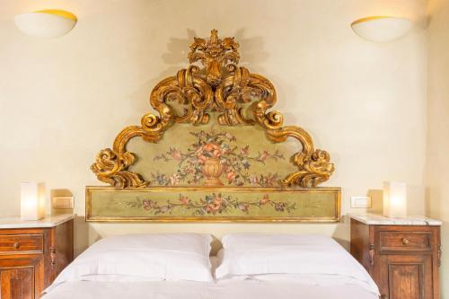 a bed with a gold headboard in a bedroom at Locanda del Vino Nobile, Montepulciano Rooms AC, WI-FI in Sant'Albino