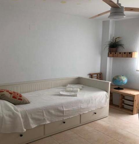 a bed in a bedroom with a white wall at VILLA MARISMAS DE LA ALMADRABA in Chiclana de la Frontera