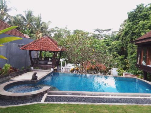 - une piscine avec un kiosque dans la cour dans l'établissement Wooden House Pool View by Malathi Villas, à Ubud
