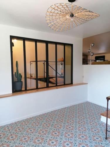 un salon avec une grande fenêtre et un plafond dans l'établissement Gîte cosy au coeur du Luberon, à Lagnes