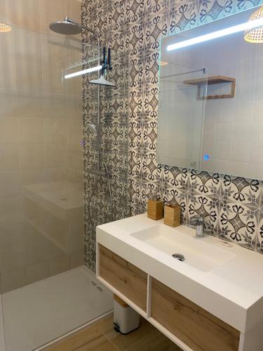 a bathroom with a sink and a shower with a mirror at Alto Club Apartments in Alvor
