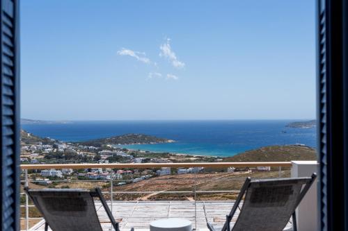 a view of the ocean from a balcony with two chairs at Stunning View Sarakiniko Villa in ayios Petros