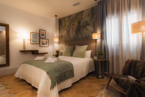 una camera da letto con un letto grande e una sedia di TuAnfitrion Constitución - Free parking a Granada