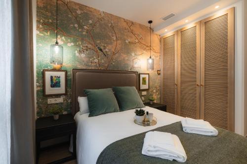 una camera da letto con un letto con due asciugamani sopra di TuAnfitrion Constitución - Free parking a Granada