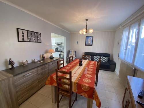 une salle à manger avec une table et un canapé dans l'établissement Maison familiale agréable proche plage et remblai - GARAGE, à Les Sables-dʼOlonne